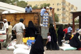 Aid workers distribute food donated by the UAE in the southern city of Aden on June 27, 2012 to Yemenis who fled the Abyan province following clashes between Yemeni government forces and Al-Qaeda fighters in the area. AFP PHOTO/STR