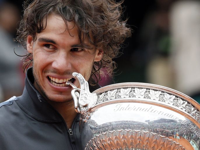 Spain's Rafael Nadal celebrates with his trophy after winning against Serbia's Novak Djokovic their Men's Singles final tennis match during the French Open tennis tournament at the Roland Garros stadium, on June 11, 2012 in Paris. AFP