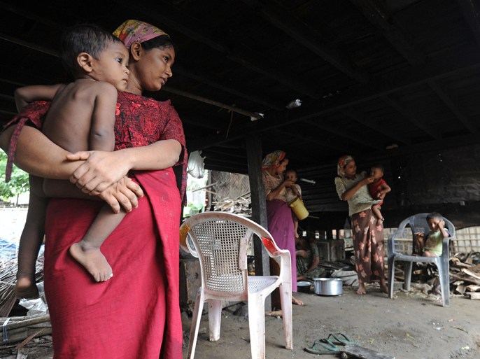 Muslim women hold their children at their house in Sittwe, capital of Myanmar's western Rakhine state on June 6, 2012. An eruption in religious tensions in Myanmar has exposed the deep divisions between the majority Buddhists and the country's Muslims, considered foreigners despite a decades-long presence. The trigger for the latest surge in sectarian tensions was the rape and murder of a woman in western Rakhine state, which borders Bangladesh, for which three Muslim men have been detained, according to state media. AFP