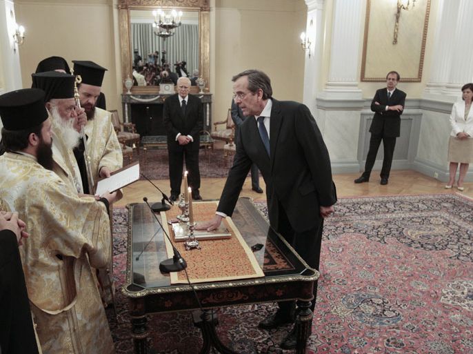 Newly appointed Greek Prime Minister Antonis Samaras (R front) is sworn in as President Karolos Papoulias (C rear) attends the ceremony at the Presidential palace in Athens June 20, 2012. Samaras pledged to pull his debt-stricken country back from the brink of bankruptcy on Wednesday in his first comments after being sworn in. REUTERS/Yorgos Karahalis (GREECE - Tags: POLITICS BUSINESS
