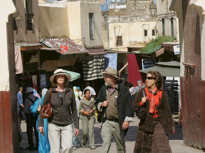 epa00703610 Tourists pass in front of the Bab Boujeloud, in Fez Morocco, on Saturday 29 April 2006.The capital of Morocco, the home of the oldest university of the country and the leading cultural and religious centre. Fez is also the oldest an largest medieval city in the world, a city that is almost unchanged through the modern ages . EPA/KHALED ELFIQI