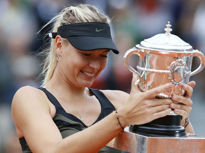 Russia's Maria Sharapova holds a trophy after winning over Italy's Sara Errani during their Women's Singles final tennis match of the French Open tennis tournament at the Roland Garros stadium, on June 9, 2012 in Paris. AFP PHOTO / PATRICK KOVARIK