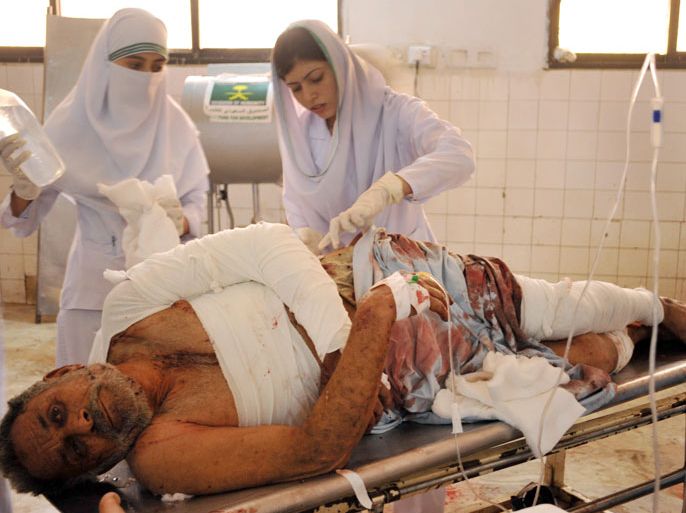 Peshawar, -, PAKISTAN : Pakistani paramedics give medical treatment to an injured blast victim at a hospital in Peshawar on June 8, 2012. A bomb blast ripped through a Pakistani bus on June 8, killing at least 18 people