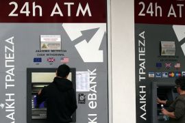 epa03126758 People use a cash machine at a branch of the Marfin Popular Bank