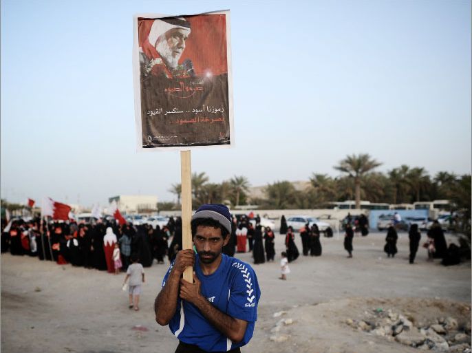A Bahraini Shiite Muslim holds a placard reading in Arabic: "Our symbols are lions who will break the chains with their persistent screams" during a demonstration in solidarity with political prisoners in the village of Abu Saiba, west of Manama, on May 31, 2012. Bahrain came under strong criticism from international rights organisations over last year's mid-March crackdown on demonstrations that were inspired by the Arab Spring uprisings. TOPSHOTS/AFP PHOTO / MOHAMMED AL-SHAIKH