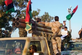 صورة لقوات الثوار أثناء عرض عسكري في بنغازي،والتعليق كالتالي فوهات المدافع استمرت حتى بعد انتهاء القذافي في دك القرى ( الجزيرة نت).