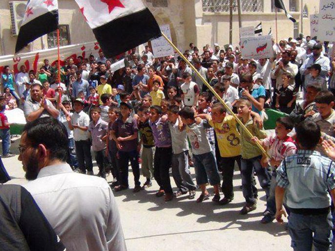 Children hold opposition flags as they take part in a protest against Syria's President Bashar al-Assad in Damascus June 15, 2012. Picture taken June 15, 2012. REUTERS