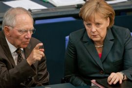 epa03264122 German Chancellor Angela Merkel (R) talks to German Finance Minister Wolfgang Schaeuble (L), after her state of the nation address before the upcoming G20 summit conference in Mexico, at the Bundestag in Berlin, Germany, 14 June 2012. Merkel defended her much criticised course in the Euro crisis and warned against excess of Germany's demands with new financial ties.