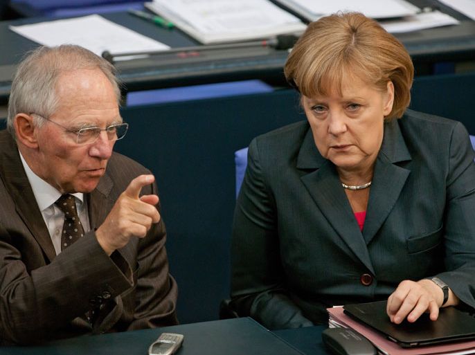 epa03264122 German Chancellor Angela Merkel (R) talks to German Finance Minister Wolfgang Schaeuble (L), after her state of the nation address before the upcoming G20 summit conference in Mexico, at the Bundestag in Berlin, Germany, 14 June 2012. Merkel defended her much criticised course in the Euro crisis and warned against excess of Germany's demands with new financial ties.