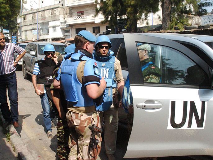 HAF55 - AL-HAFFE, -, SYRIA : A photo released by the state-run Syrian Arab News Agency (SANA) showsa team of United Nations observers touring the Syrian town of al-Haffe in the Mediterranean province of Latakia with an official Syrian security escort on June 14, 2012