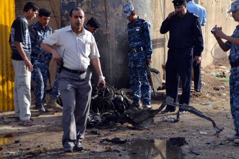 epa03263420 Iraqi policemen inspect the remains of a car used in a bomb attack in Hilla, south of Baghdad, Iraq, 13 June 2012. At least 70 people were killed