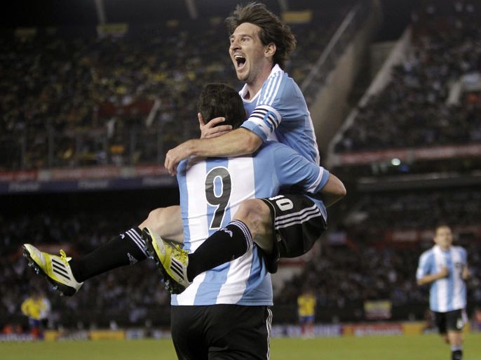 epa03247007 Lionel Messi (R) of Argentina celebrates with his teammate Gonzalo Higuain after scoring against Ecuador during a soccer match as part of Qualifying to Brazil 2014 World Cup at the Antonio Vespucio Liberti stadium in Buenos Aires, Argentina, 02 June 2012. EPA/LEO LA VALLE