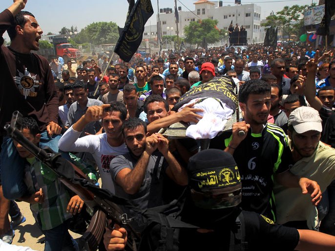 : Palestinian mourners carry the body of one of the two Palestinians who were killed in an Israeli air strike on north Gaza during their funeral on June 18, 2012. Witnesses identified the two men as members of the radical Islamic Jihad movement and said they were riding a motorcycle near the Israeli border at the time. AFP PHOTO/MAHMUD HAMS