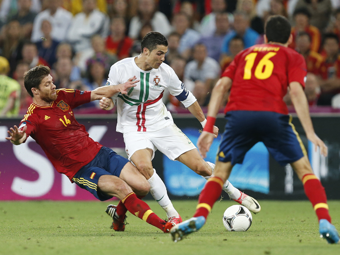 epa03284718 Portuguese player Cristiano Ronaldo (c) in action against Spanish players Xabi Alonso (L) and Sergio Busquets (R) during the semi final match of the UEFA EURO 2012 between Portugal and Spain in Donetsk, Ukraine, 27 June 2012.  EPA