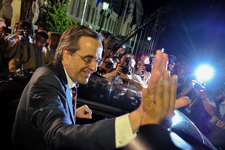 New Democracy party leader, Antonis Samaras (Bottom C), waves to supporters as he leaves at the end of a press conference after his party came first in the national Greek's election, at the Zappion Hall in central Athens, on June 17, 2012. Greece's two main pro-bailout parties clinched enough votes to form