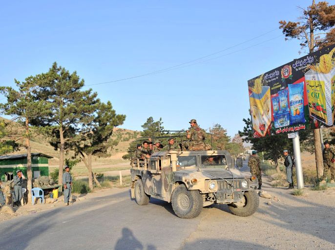 Afghan National Army (ANA) soldiers ride in military vehicles following an attack on a hotel near Qargha lake, outskirts of Kabul on June 22, 2012. Taliban militants armed with rockets and automatic weapons mounted a suicide attack