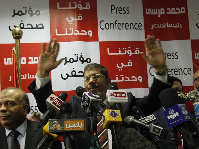 EGYPT : Egypt's Muslim Brotherhood candidate Mohammed Mursi (C) waves amongst his supporters after the announcement of presidential election results at the electoral headquarters in Cairo on June 18, 2012. The campaign of Egyptian presidential candidate Ahmed Shafiq said on June 18 it contested a claim by the Muslim Brotherhood that its candidate Mohammed Mursi had won a historic presidential election. AFP PHOTO / MOHAMMED ABED
