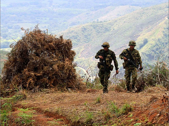 Colombian soldiers walk in the rural area of Miranda in Cauca June 28, 2012. Peasants and the indigenous community asked the army to remove a military base that was built on their territory, which endangered their lives as a result of clashes with guerrillas of the Revolutionary Armed Forces of Colombia (FARC). REUTERS/Jaime Saldarriaga (COLOMBIA - Tags: CIVIL UNREST MILITARY POLITICS)