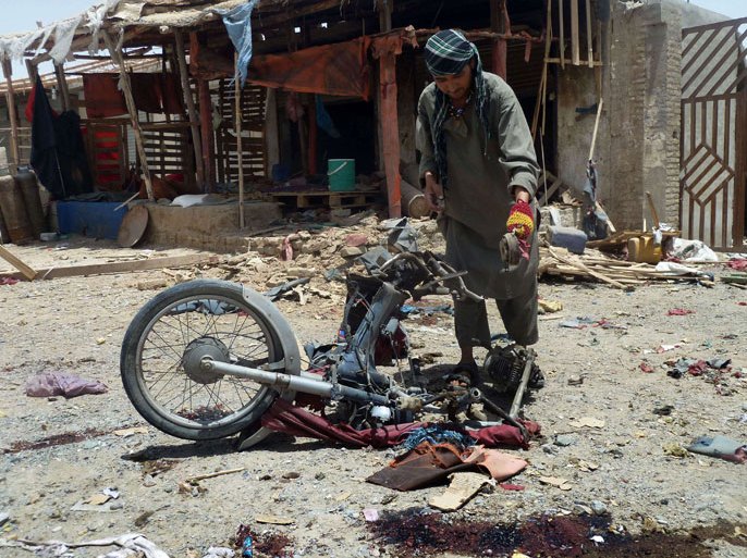 SM034 - Kandahar, -, AFGHANISTAN : An Afghan man inspects a motorcycle used in a suicide attack in a parking lot holding dozens of trucks supplying the NATO-run Kandahar Air Base on June 6, 2012. A twin suicide bombing attack killed 23 people on June 6 in a car park crammed with vehicles supplying a major NATO base in Afghanistan's southern province of Kandahar, police said.