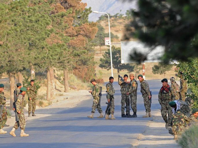 Afghan National Army (ANA) soldiers stand guard along a road following an attack on a hotel near Qargha lake, outskirts of Kabul on June 22, 2012. Taliban militants armed with rockets and automatic weapons mounted a suicide attack on a hotel at a popular Kabul beauty spot on June 22,