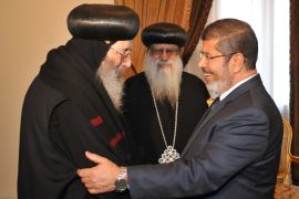 In this handout picture made available by the Egyptian presidency, Egypt's president-elect Mohamed Morsi shakes hands with Coptic Bishop Beshoy during a meeting with a Christian delegation headed by the caretaker pope of the country's Coptic Church, Bishop Pachomius (C), at the presidential palace in Cairo on June 26, 2012. AFP