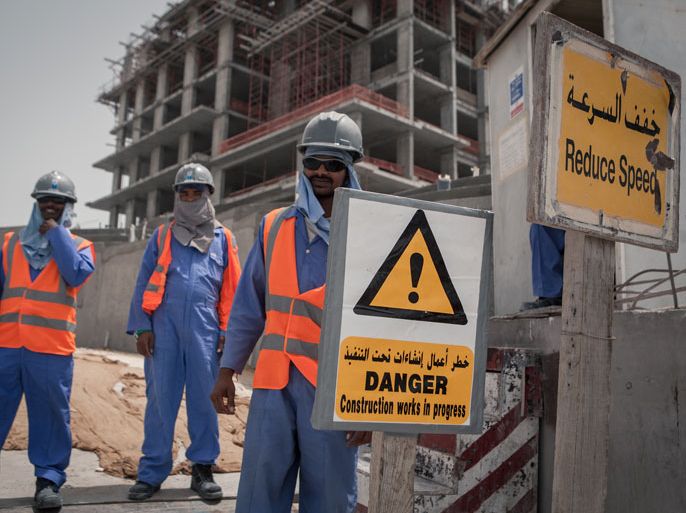 Qatar: Migrant construction workers pose for a picture outside of their work site at The Pearl, a man-made chain of islands off the coast of northern Doha, which hosts dozens of high-rise luxury apartment complexes, villas, restaurants, and shops. - Photo source: Human Rights watch