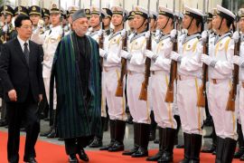 Chinese President Hu Jintao and Afghan President Hamid Karzai (C) review an honour guard during his welcoming ceremony at the Great Hall of the People in Beijing on June 8, 2012