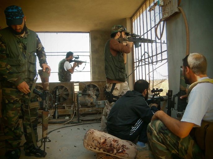 QUSAYR, -, SYRIA : A handout picture released by the Syrian opposition's Shaam News Network on July 17, 2012, allegedly shows a Free Syrian Army militants aiming fire at a base in Qusayr on July 16