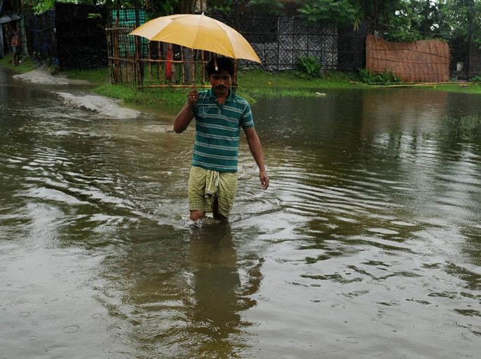INDIA : Indians residents wade through waterlogged roads in Dhantola village on the outskirts of Siliguri on July 6, 2012. Continuous rainfall in the last 48 hours has caused a flood-like situation in Jalpaiguri and adjoining areas of North Bengal as the