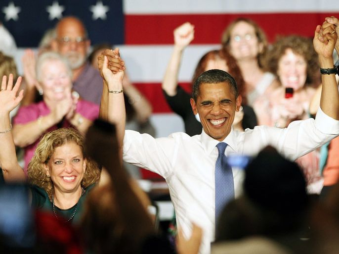 WEST PALM BEACH, FL - JULY 19: U.S. President Barack Obama raises arms with Congresswoman Debbie Wasserman Schultz (D-FL) after delivering remarks to seniors at Century Village on July 19, 2012 in West Palm Beach, Florida. Obama is campaigning for two days in Florida, a crucial swing state in November's presidential election