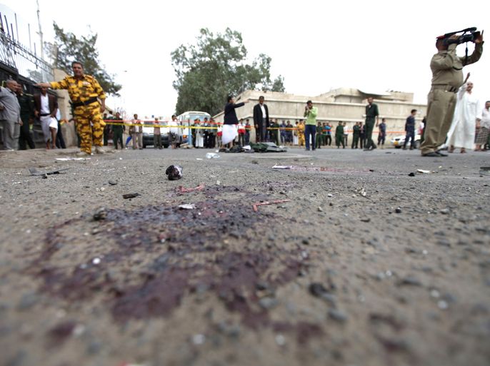 Policemen inspect the site of a suicide bombing outside the police academy in Sanaa July 11, 2012. At least 22 people were killed in a suicide bombing at a police academy in the Yemeni capital Sanaa on Wednesday, an attack, police investigators said bore the hallmarks of al Qaeda. REUTERS