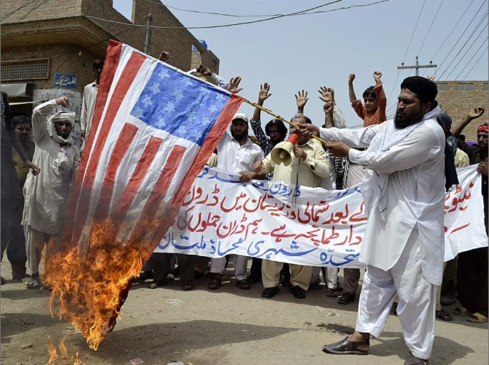 An activist of Muttahida Sheri Mahaz burns US flag during a protest in Multan on July 7, 2012, against the recent US drone attack. A triple US drone attack on a militant compound in Pakistan's northwestern tribal area killed at least 15 insurgents late on Jyly 6, security officials said. AFP PHOTO / S S MIRZA