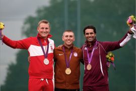 Gold medallist Vincent Hancock of the United States (C) poses on the podium with silver medalist Denmark's Anders Golding (L) and bronze medalist Qatar's Naser al-Attiya (R) after winning the skeet men's final at The Royal Artillery Barracks in London on July 31, 2012, during The London 2012 Olympic Games. Hancock set a new Olympic record scoring 148 points. AFP PHOTO/MARWAN NAAMANI