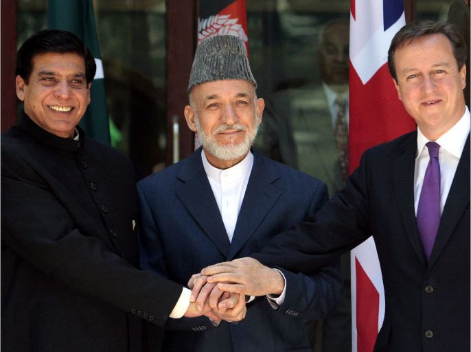 epa03311568 Afghan President Hamid Karzai (C) joins hands with British Prime Minister David Cameron (R) and Pakistani Prime Minister Raja Pervaiz Ashraf during a trilateral meeting at the presidential palace in Kabul, Afghanistan, 19 July 2012. Cross-border fighting and stalled negotiations with the Taliban were the main topics of discussion at the three-way meeting between Pakistani Prime Minister Raja Pervaiz Ashraf, Afghan President Hamid Karzai and Cameron. EPA/MUSADEQ SADEQ / POOL