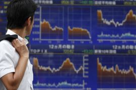 A man looks at an electronic board displaying graphs of various market indices outside a brokerage in Tokyo July 23, 2012. Japan's Nikkei share average posted its biggest fall in a month and a half as it sank to a six-week low on Monday, hit by renewed fears that Spain may need a full-blown bailout and by the subsequent rise in the yen. REUTERS/Yuriko Nakao (JAPAN - Tags: BUSINESS EMPLOYMENT