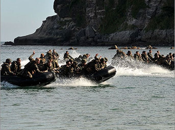 (files) file photo taken on october 11, 2010 shows us marines and their philippine counterparts approach a beach on rubber boats to secure a hill during joint military training exercises in cavite, south of manila. state-of-the-art us missile destroyers will join ageing philippine warships for naval exercises this week in a timely show of unity as tensions with china escalate (الفرنسية)