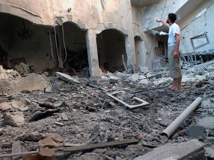 A man inspects a destroyed house in Bab-Todmor in Homs July 12, 2012. Picture taken July 12, 2012. REUTERS/Yazen Homsy (SYRIA - Tags: POLITICS CIVIL UNREST)