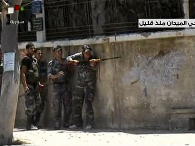 An image grab taken from Syrian TV shows Syrian security forces taking position during armed clashes with gunmen who the TV called "terrorists" (unseen) in the Al-Midan district of Damascus on July 18, 2012. Rebel forces said the battle to "liberate" Damascus had begun, as heavy fighting raged with the regime using helicopter gunships in the capital for the first time. AFP PHOTO / HO / SYRIAN TV