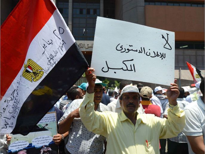 An Egyptian man holds up a sign that reads in Arabic, "No to a regimented constitution ", as hundreds of Egyptian supporters of Muslim Brotherhood take part in a demonstration outside the administration Court in Cairo on July 17, 2012, as the courts look at the case of the constitution committee. AFP PHOTO/KHALED DESOUKI