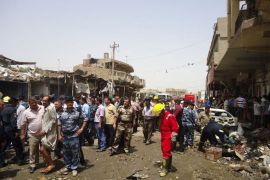 Iraqi rescue and security personnel look at the destruction following a truck bomb in a crowded market in the central Iraqi city of Diwaniya that killed at least 25 people on July 3, 2012, the latest victims of a spike in nationwide violence medical and security officials said