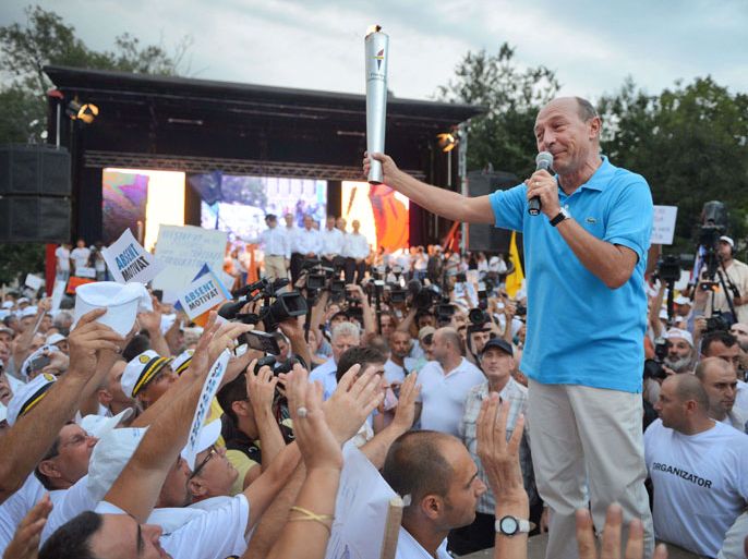 DAN019 - Bucharest, -, ROMANIA : Romanian President Traian Basescu holds "The Flame of Democracy" as he speaks during an electoral rally in Bucharest July 26, 2012. Romanians will vote on July 29 in a referendum regarding the impeachment of Romanian President Traian Basescu.
