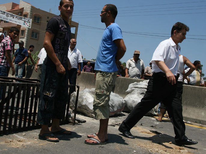 LEBANON : Lebanese protestors use bags of earth and metal scraps to block the main road from the coastal city of Tripoli that leads to the villages of the northern province of Akkar on July 6, 2012 during a protest against the handling of the investigation into the killing of a Sunni Muslim cleric by army troops at a checkpoint on the boarder with Syria in May 2012. AFP PHOTO /