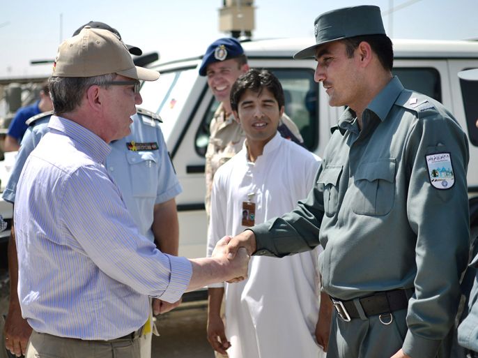 German Defence Minister Thomas de Maiziere (L) shakes hands with Afghan soldiers upon arrival at the ISAF camp in Kunduz, on July 03, 2012. De Maiziere arrived for a short visit to German soldiers stationed in Afghanistan. AFP
