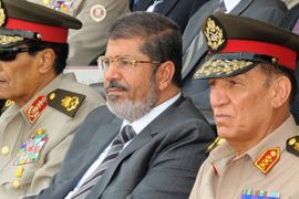 A handout picture released by the Egyptian Presidency shows Egyptian President Mohamed Morsi (C), head of the military council Field Marshal Hussein Tantawi (L) and Egyptian armed forces Chief of Staff Sami Anan (R) attending a graduation ceremony of military cadets, in Cairo, Egypt, 09 July 2012. Media reports state that Egypt's Supreme Constitutional Court on 09 July 2012 insisted it was correct in disbanding the lower house of parliament and that its verdicts are binding upon all authorities. Morsi, who took office late last month, decreed on 08 July the Islamist-dominated chamber to reconvene and called for an early parliamentary election 60 days after a constitution currently being drafted is approved in a referendum. EPA/MOHAMED SMAHA/EGYPTIAN PRESIDENCY CROPPED VERSION OF epa03301739 HANDOUT EDITORIAL USE ONLY/NO SALES