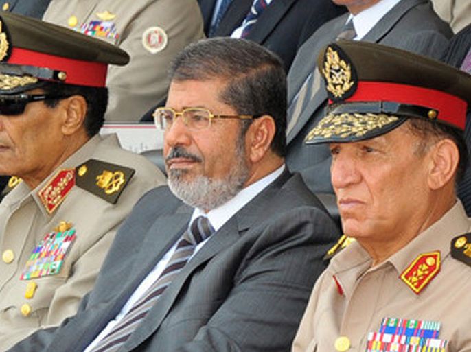 A handout picture released by the Egyptian Presidency shows Egyptian President Mohamed Morsi (C), head of the military council Field Marshal Hussein Tantawi (L) and Egyptian armed forces Chief of Staff Sami Anan (R) attending a graduation ceremony of military cadets, in Cairo, Egypt, 09 July 2012. Media reports state that Egypt's Supreme Constitutional Court on 09 July 2012 insisted it was correct in disbanding the lower house of parliament and that its verdicts are binding upon all authorities. Morsi, who took office late last month, decreed on 08 July the Islamist-dominated chamber to reconvene and called for an early parliamentary election 60 days after a constitution currently being drafted is approved in a referendum. EPA/MOHAMED SMAHA/EGYPTIAN PRESIDENCY CROPPED VERSION OF epa03301739 HANDOUT EDITORIAL USE ONLY/NO SALES