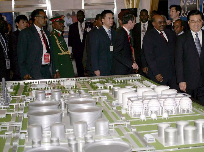 epa00921264 Sudanese President Omar al-Bashir, (2-R) and his Chinese counterpart Hu Jintao, (R) front, look at a mock compound of the Khartoum oil-refinery during his visit to the facility in the town of Jayli, 80 klm North of Khartoum, Sudan on Friday 02 February 200 EPA/PHILIP DHIL