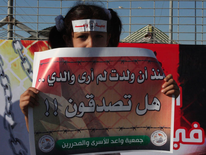 طفلة أثناء اعتصام بغزة تحمل لافتةعن منعها من زيارة والدها المعتقل (الجزيرة)