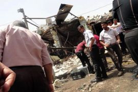 IRAQ : Iraqis gather at the scene following a truck bomb in a crowded market in the central Iraqi city of Diwaniya that killed at least 25 people on July 3, 2012, the latest victims of a spike in nationwide violence medical and security officials