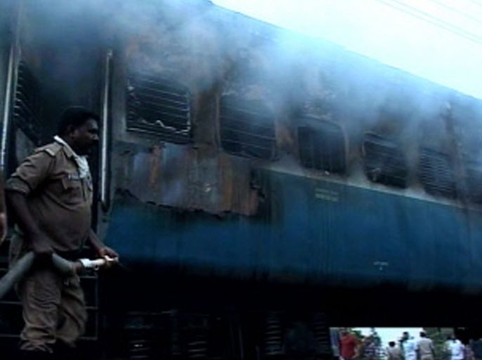 This video grab from New Wire Service on July 30, 2012 shows rescue personnel at the scene as smoke continues to smolder from a burnt out rail car after a fire ripped through a coach on a speeding express train near the town of Nellore in Andhra Pradesh state