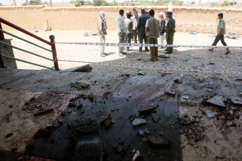 Afghan officials stand at the site of attack in Samangan province July 14, 2012. A suicide bomber blew himself up at a wedding reception in northern Afghanistan on Saturday, killing at least 22 people including a prominent politician, and wounding 40 others, police said. REUTERS